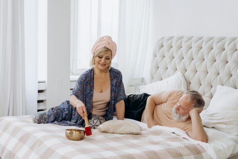 A couple enjoying relaxation with a Tibetan singing bowl in a bright bedroom.